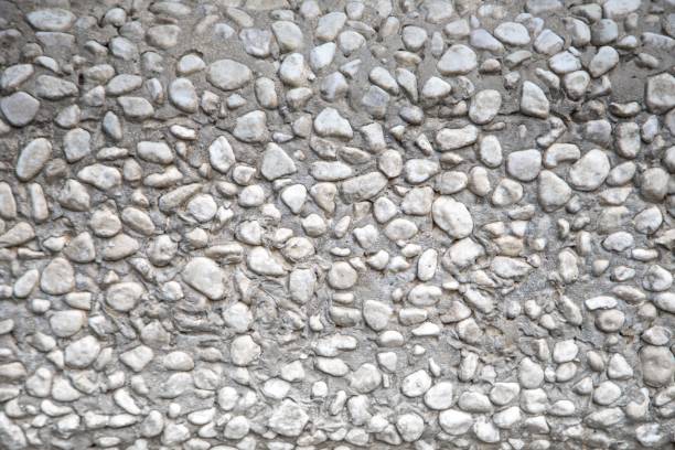 istock Gray cement construction with stones results in a rocky texture material 1444073160