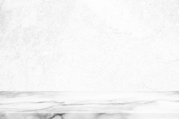 istock Marble Table with White Grunge Concrete Wall Background. 1444074471
