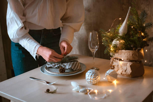 istock young woman decorates and sets a festive Christmas table with a spruce composition 1444077012