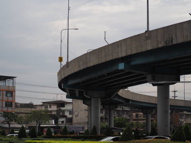 istock Gray expressway, silver sky, clouds and gray-orange buildings, light gray white. 1444077463