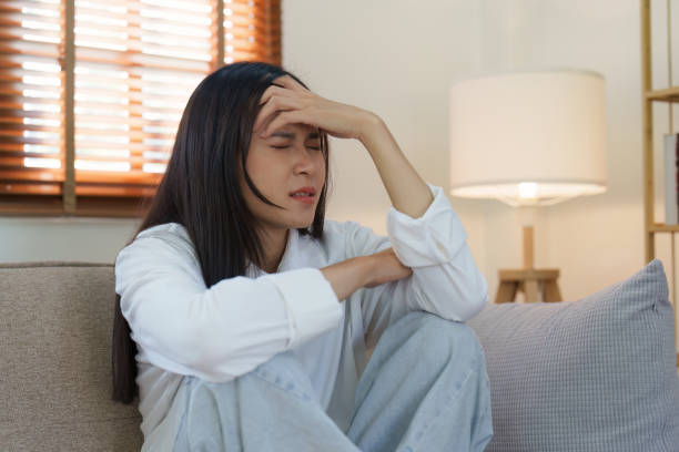 istock Young asian woman feeling miserable and lonely on sofa at home 1444082549
