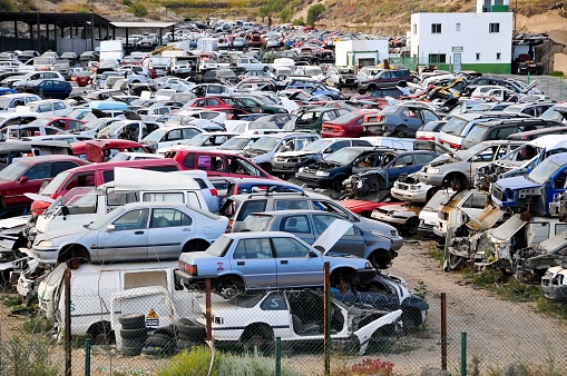 A shot of a junkyard of old colorful cars placed on top of each other