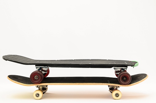 A shot of two skateboards on top of each other with a white background