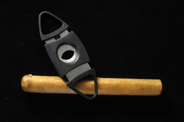 Cuban Brown Cigar and Cutter on a black background A Cuban Brown Cigar and Cutter on a black background s whiskey and cigar stock pictures, royalty-free photos & images