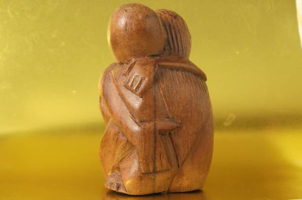 istock Wooden Lovers Sculpture on a Gold Background 1444083785