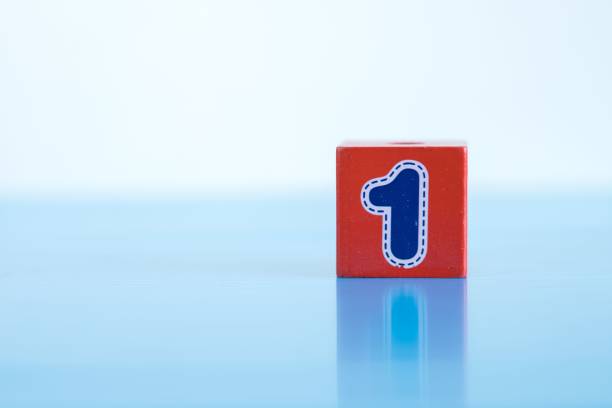 istock Blue number 1 on a red wooden block isolated on blue background. 1444084601