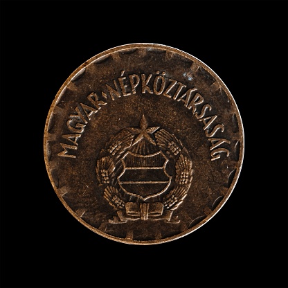 A Hungarian coin over a black background