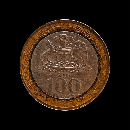 An old coin, 100 pesos, over a black background
