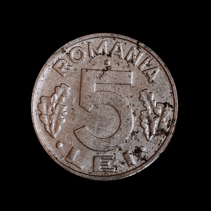 A Romanian five Lei coin isolated on a black background