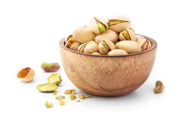 Pistachio in wooden bowl isolated on white background
