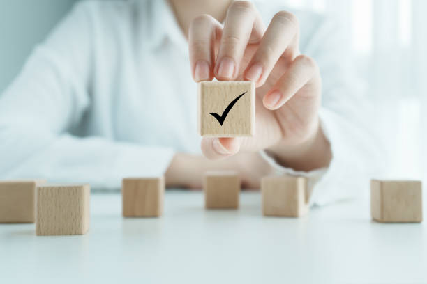 istock Elections and Voting, Vote, to do list, checklist, Task list, Survey and assessment concept. Hand showing check mark on wooden block. 1444086620
