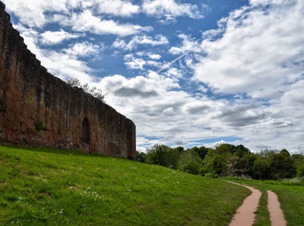 istock Low-angle shot of an old brick wall next to a beautiful field 1444087017