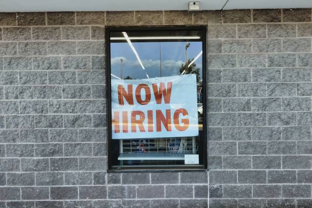 istock Now hiring sign seen through a window glass 1444087720