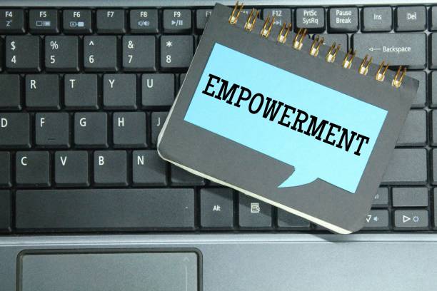istock laptop keyboards, notebooks, colored paper with the word empowerment 1444088339
