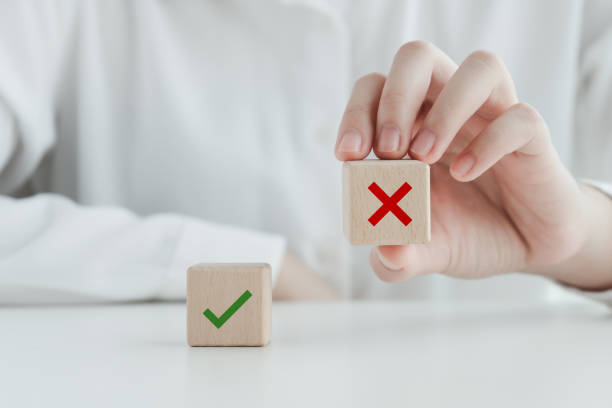 Human pick wrong or red cross icon on wood cube from green check mark for true or false mindset or elections vote, survey and assessment to change leader and transform quiz answer and poll concept.