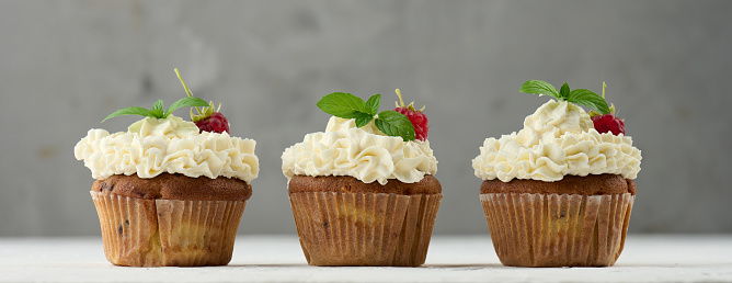 Baked cupcakes with white butter cream on the table, delicious dessert