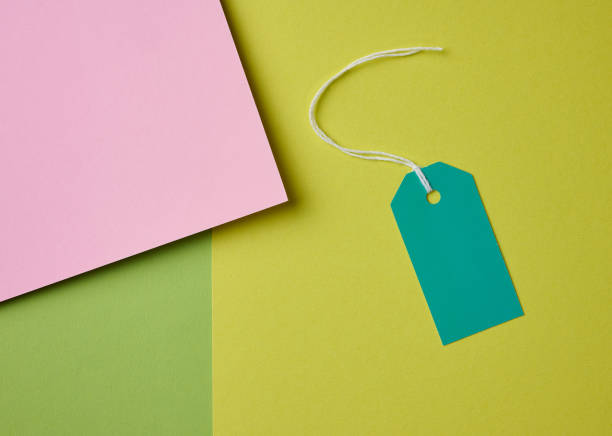 istock Blank pink cardboard tag on white rope, green background 1444092053