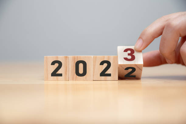 Hand of man flip wooden cube from 2022 to 2023. stock photo