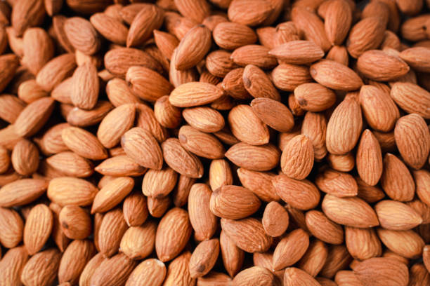istock Almonds in white porcelain bowl on white table. Almond concept with copyspace. 1444093683