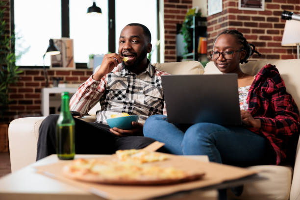 istock African american couple eating chips and using laptop 1444095225