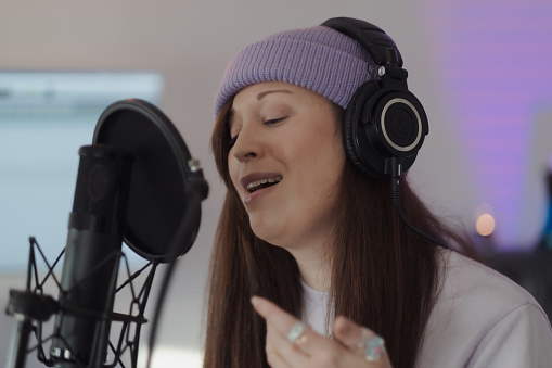 Singer/songwriter Criibaby in the studio, performing their new music. Their lyrics are not gender specific, and are informed by their lived experience as femme and nonbinary.