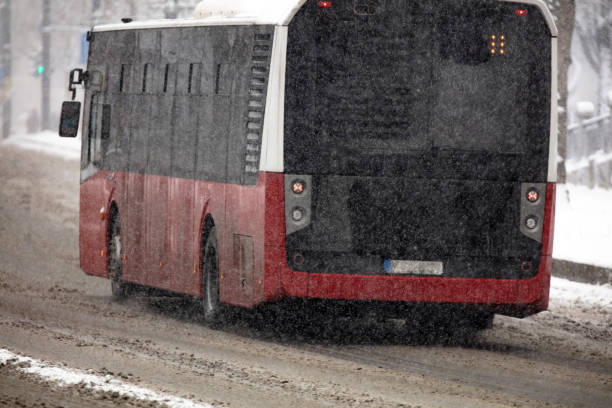 transporte público en autobús que conduce por calles nevadas en condiciones invernales. - public transportation winter bus front view fotografías e imágenes de stock