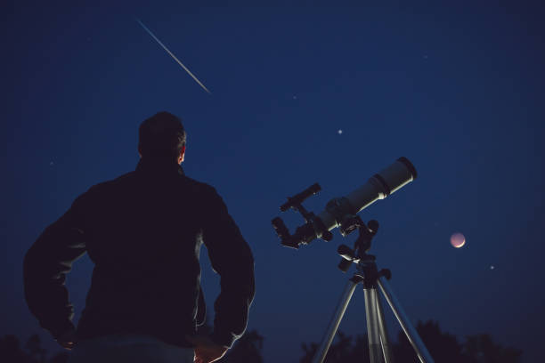 Silhouette of a man, telescope, stars, planets and shooting star under the night sky. Silhouette of a man, telescope, stars, planets and shooting star under the night sky. meteor shower stock pictures, royalty-free photos & images