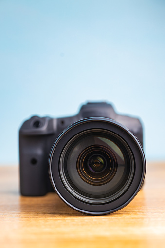 Digital mirrorless camera on the wooden table.