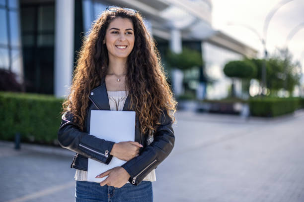 istock University student holding her laptop 1444103872