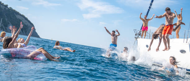 istock Friends jumping in sea 1444105521