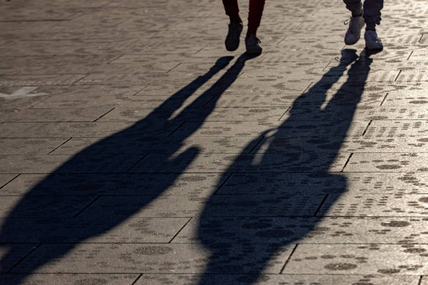 shadow of people walking on the street stock photo