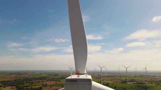 Male Inspection engineers standing on top of a wind turbine and looking beautiful landscape