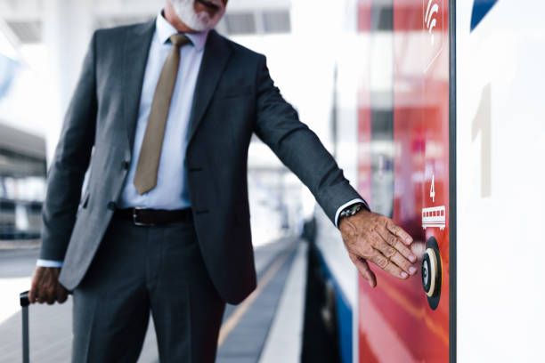 駅のホームで電車のドアボタンを押し開くビジネスマンの中央部。 - train door vehicle door open ストックフォトと画像