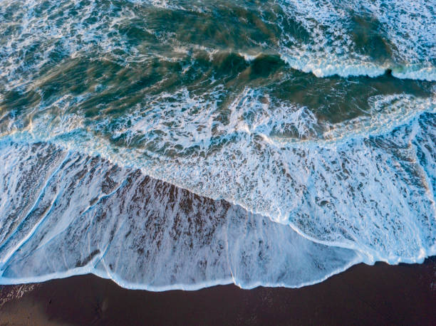aerial shot of waves coming ashore along the coast stock photo