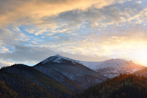 Sunset in the mountains. Autumn evening landscape with snowy mountains