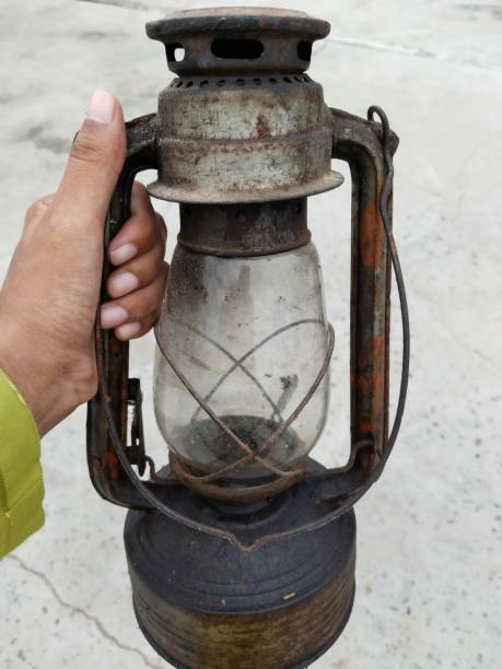 istock Old oil lantern or lamp holding with hand 1444113019