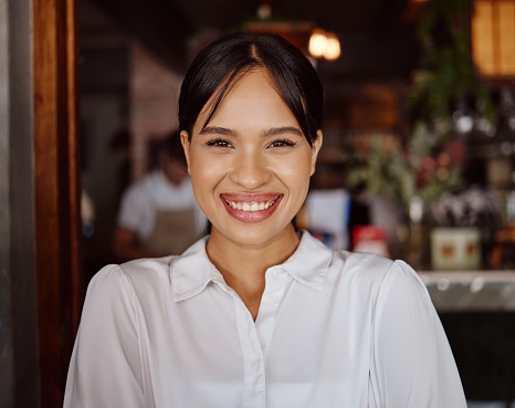 Happy, business owner and waitress working at a restaurant with smile for management job at a cafe. Face portrait of black woman, boss or worker in happiness for success at a fine dining coffee shop