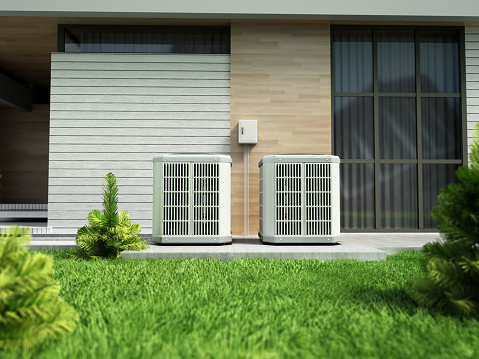 Heat pumps outside the modern house, installed near the wall.
