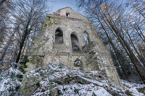 Wide angle shot of an old damaged gothic chapel in winter.
