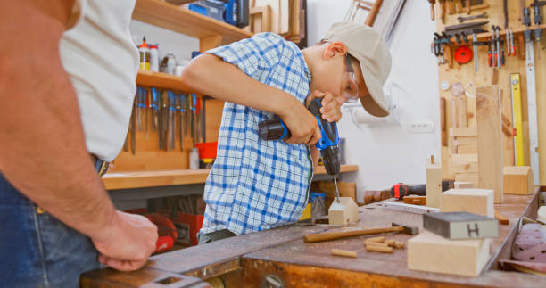 istock Boy drilling hole on wooden house 1444119363