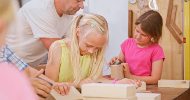 istock Children with carpenter sanding wooden blocks 1444119403