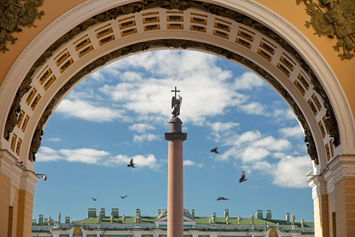Alexandrian pillar with doves at the Palace Square in frame of arch of military headquarters in St. Petersburg