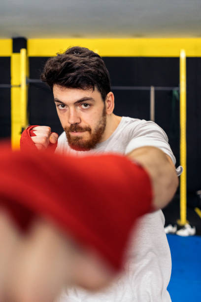 istock Kickboxing fighter performing punches looking at camera at the gym 1444121359
