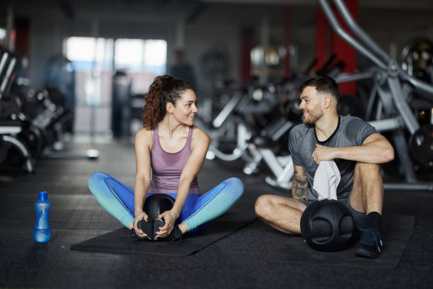 istock Happy athletic couple talking while resting a break in a gym. 1444123041