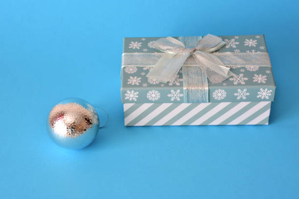 istock christmas box with silver sphere isolated on blue background 1444123180