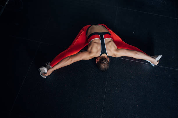 An attractive young woman smiling while using the barrier to stretch forward