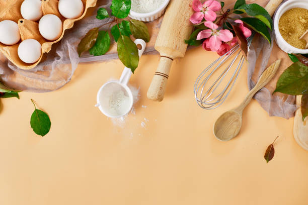 istock Bakery  or cooking frame with flower, ingredients, kitchen items for pastry on pastel orange background,  spring cooking theme. Top view, copy space. 1444126321