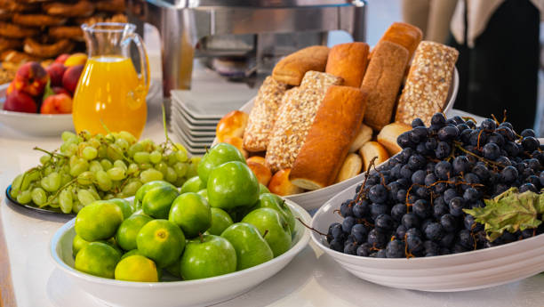istock Fresh raw fruit, orange juice, apples, grapes, peaches, bagels and breads on a modern white kitchen table. Healthy eating. Organic food. 1444127000
