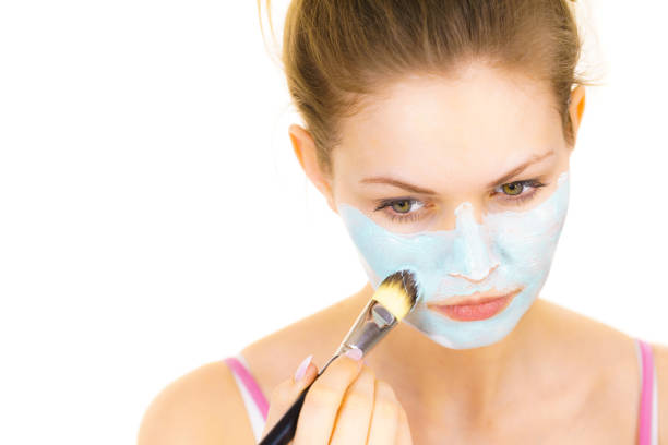 istock Girl apply green mud mask to face 1444128970