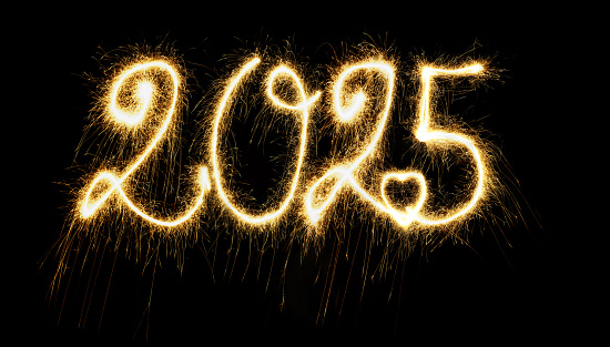 Sparkling  Year 2025 painted with sparkles. Written on a deep black background.